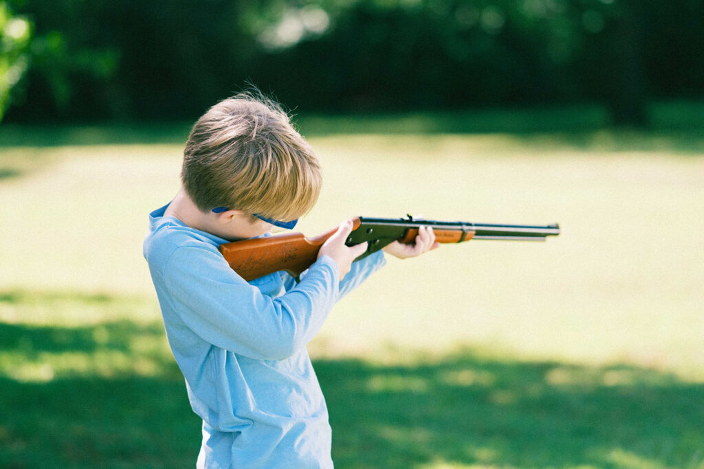Young boy in safety glasses shoots Daisy Legacy BB gun